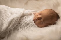 Windelndes Neugeborenes schläft auf flauschiger Decke. — Stockfoto