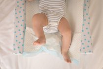 Primo piano del bambino in costume da bambino sdraiato sul letto a casa — Foto stock