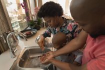 Famille avec fils se lavant les mains dans la cuisine à la maison . — Photo de stock