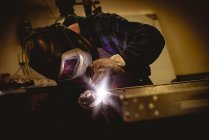 Працівник, який працює на виготовлених металевих деталях на заводі — стокове фото