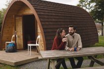 Heureux couple prenant un café à l'extérieur de la cabane — Photo de stock