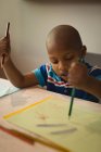 Bambino prescolare disegno schizzo su carta a tavola . — Foto stock