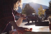 Mulher pulverizando água enquanto limpava a mesa no café ao ar livre — Fotografia de Stock