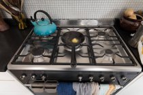 Gros plan de cuisinière à gaz avec bouilloire et poêle dans la cuisine à la maison . — Photo de stock