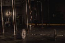 Barbell noire sur un plancher de gym — Photo de stock