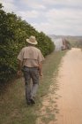 Visão traseira do agricultor caminhando na fazenda laranja — Fotografia de Stock