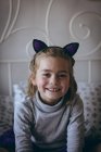 Портрет усміхненої дівчини, що сидить на ліжку в спальні — стокове фото
