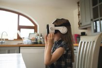 Жіноча дитина відчуває гарнітуру віртуальної реальності на кухні вдома — стокове фото