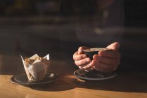 Seção média de mulher tomando café e café da manhã no café — Fotografia de Stock
