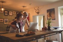 Лесбиянки используют ноутбук в гостиной . — стоковое фото