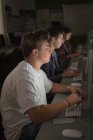 Estudiantes universitarios que estudian en aula de informática en la universidad - foto de stock