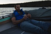 Mann bereitet Köder für Fischfang auf Motorboot vor. — Stockfoto