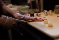 Koch filetiert Fisch in der Restaurantküche auf einem Schneidebrett — Stockfoto