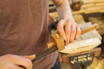 Male carpenter measuring marking gauge with ruler in workshop — Stock Photo
