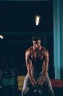 Мускулистый мужчина занимается с гирями в фитнес-студии — стоковое фото