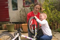 Mutter und Sohn reparieren gemeinsam Fahrrad im Hinterhof — Stockfoto