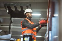 Männlicher Arbeiter überprüft Maschinenteil in Fabrik — Stockfoto
