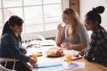 Женщины-руководители завтракают вместе в креативном офисе — стоковое фото
