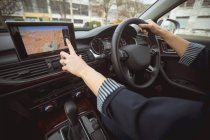 Женщина руководитель с помощью навигации во время вождения современного автомобиля — стоковое фото