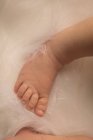 Primer plano del pie del bebé recién nacido sobre una manta esponjosa . - foto de stock