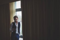 Geschäftsmann benutzt Handy im Hotelzimmer — Stockfoto