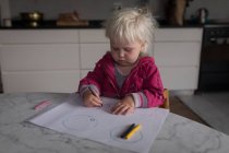 Маленькая девочка рисует цветными карандашами дома . — стоковое фото