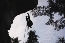 Vista a basso angolo dell'arrampicatore che lotta sulla montagna rocciosa — Foto stock