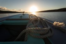 Nahaufnahme von Seil in Motorboot im Fluss bei Sonnenuntergang. — Stockfoto