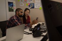 Geschäftskollegen nutzen Handy am Schreibtisch im Büro — Stockfoto