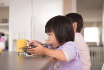 Sibling having breakfast at table in kitchen — Stock Photo