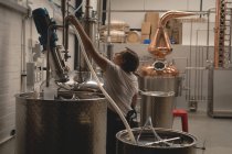Trabalhadora do sexo feminino máquina de verificação de destilaria na fábrica — Fotografia de Stock