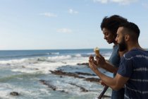 Couple ayant crème glacée près de la mer par une journée ensoleillée — Photo de stock