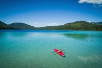 Kayaker kayak in acque turchesi poco profonde in una giornata di sole — Foto stock