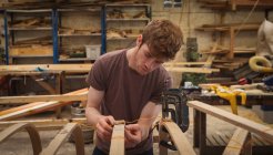 Jovem carpinteiro do sexo masculino trabalhando em oficina — Fotografia de Stock