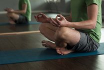 Niedriger Teil der Menschen praktiziert Yoga im Studio. — Stockfoto