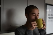 Jovem tomando café em casa — Fotografia de Stock