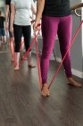 Faible proportion de femmes faisant de l'exercice avec des bandes de résistance dans un studio de fitness . — Photo de stock