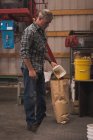 Homem de embalagem de grãos refinados na fábrica — Fotografia de Stock