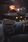 Abgeschnittenes Bild einer Frau, die zu Hause eine Tasse Tee hält — Stockfoto