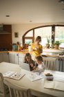 Матері, спостерігаючи дітей, використовуючи ноутбук кухні в домашніх умовах — стокове фото