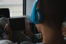 Молодий чоловік слухає музику на цифровому планшеті у вітальні вдома — стокове фото