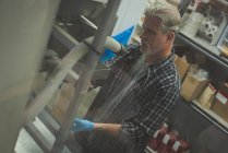 Чоловік переробляє зерно в машині на заводі — стокове фото