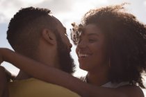 Nahaufnahme eines lächelnden Paares, das sich an einem sonnigen Tag umarmt — Stockfoto