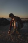 Pai e filho brincando na areia na praia durante o pôr do sol — Fotografia de Stock