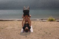 S'adapter couple pratiquant l'acro yoga dans un terrain vert luxuriant au moment de l'aube — Photo de stock