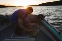 Mann bereitet Köder für Fischfang auf Motorboot vor. — Stockfoto