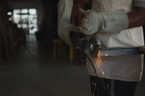 Плотник резки металла с электропилой в мастерской — стоковое фото