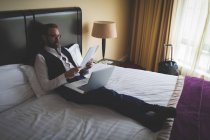 Бізнесмен читає документ у готельному номері — стокове фото