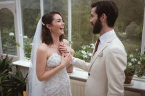 Felice sposo mettendo la mano sul petto spose — Foto stock