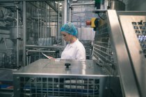 Macchina di monitoraggio operaia femminile in fabbrica — Foto stock